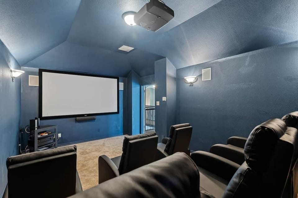 Media room with reclining chairs, 120 inch screen and sound system.