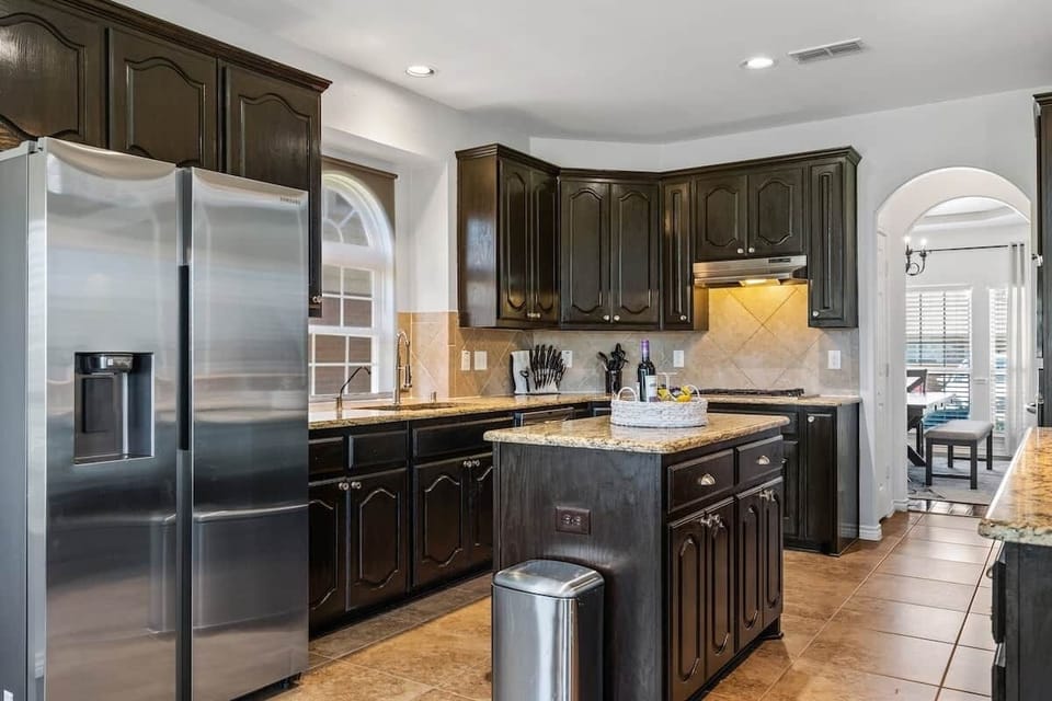 Kitchen with refrigerator, counter, cooking area view with kitchenette. 