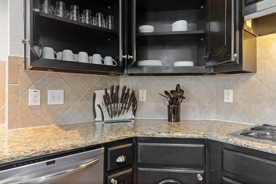 Kitchen displaying kitchenette, dishes, cups, knives etc.