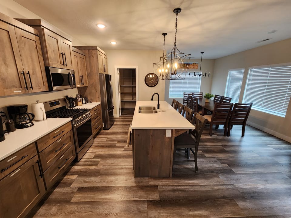 Well-stocked kitchen with stainless steel appliances, dining table with 8 seats.