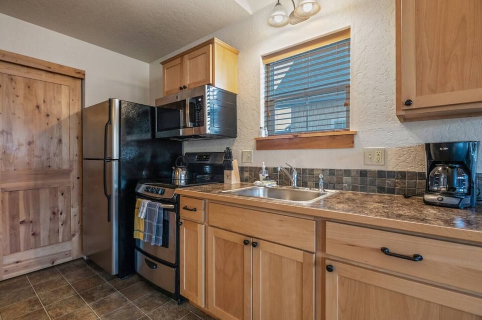 Cute kitchen furnished with cooking essentials.