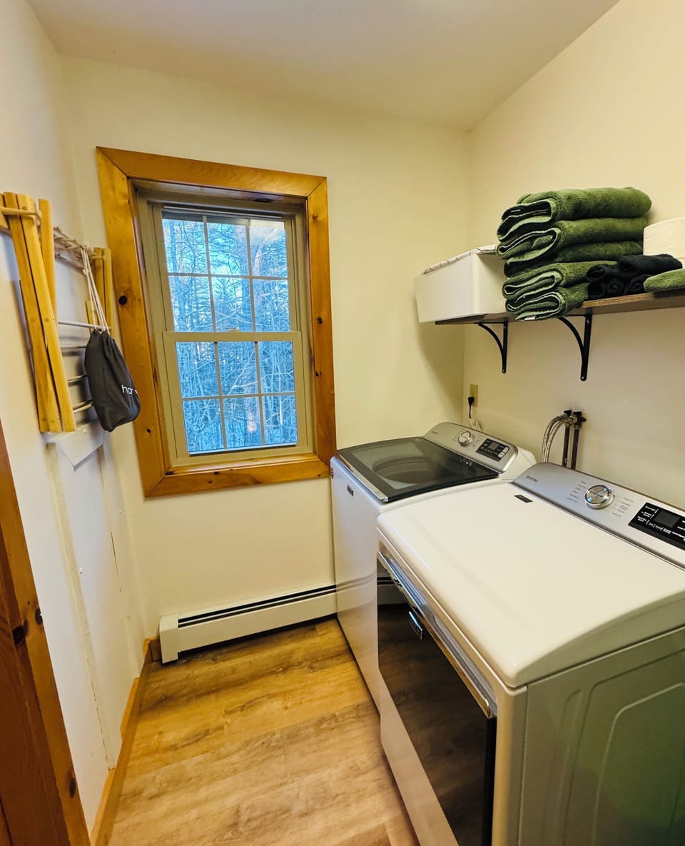 The laundry space is on the main floor. Washer, dryer, iron, and drying rack