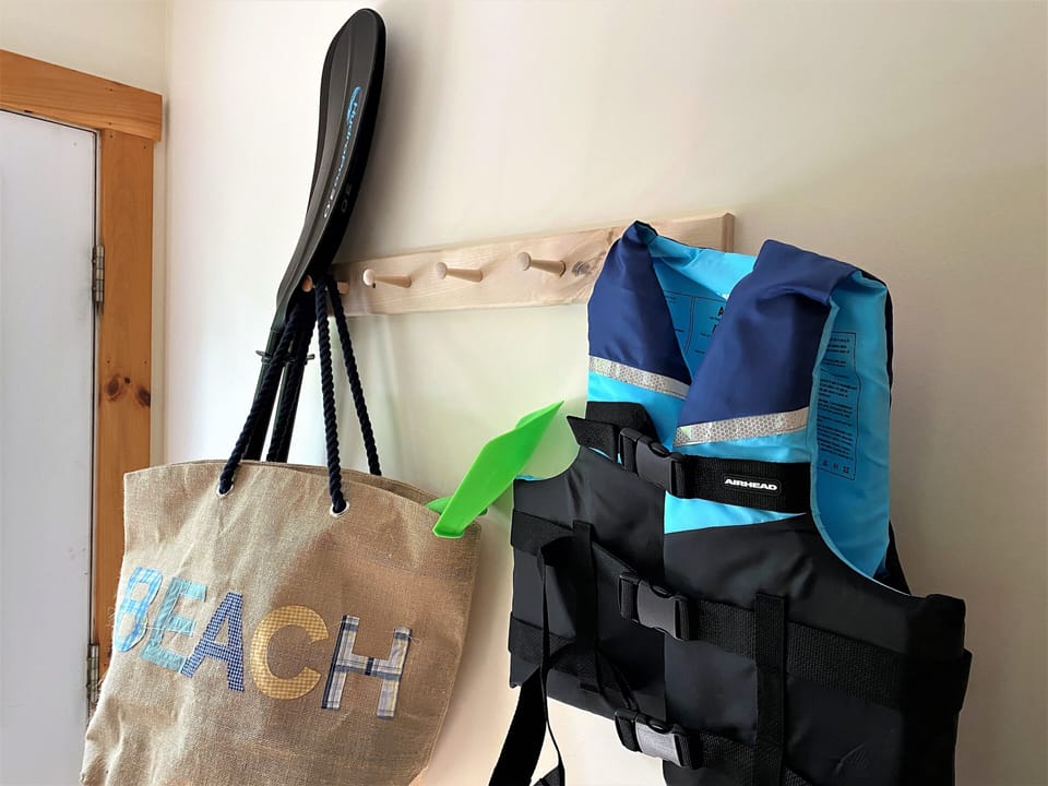 Sand toys, lifejackets, and paddles stand ready for a day at the beach.