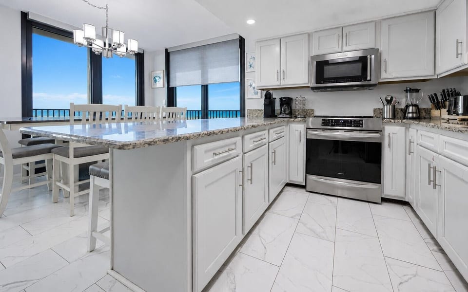 Upgraded kitchen features granite countertops, light cabinetry, and a coffee corner with a Keurig and coffee maker