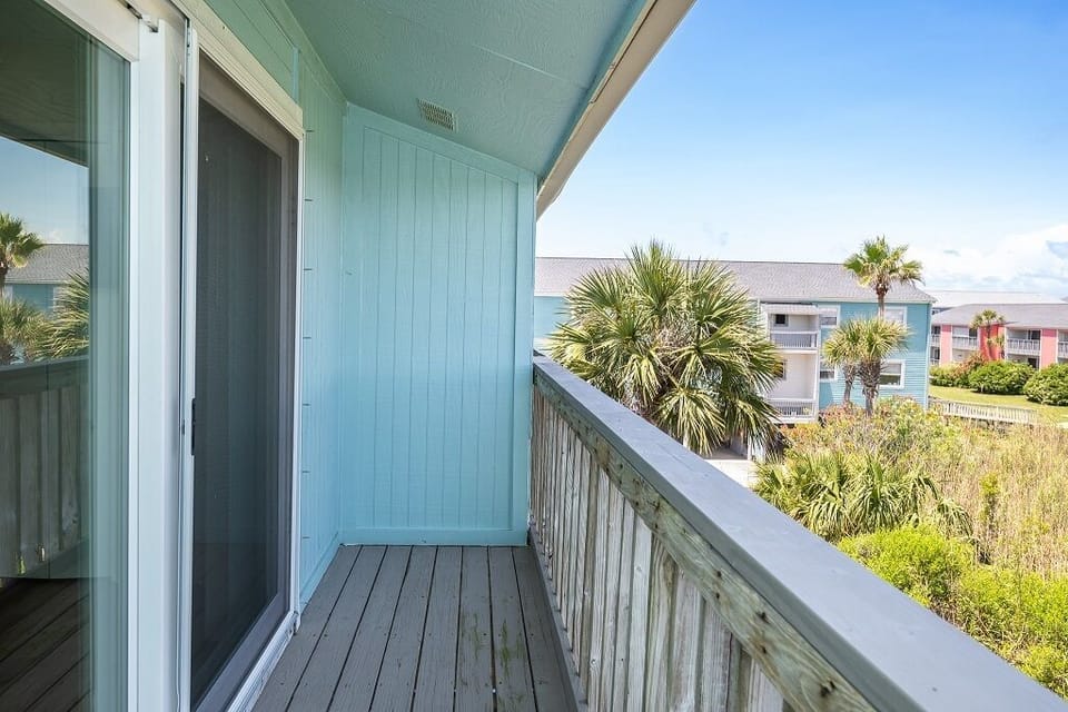 Your private balcony overlooks swaying palms and coastal greenery, offering a peaceful retreat with fresh ocean breezes and serene views of the surrounding area.
