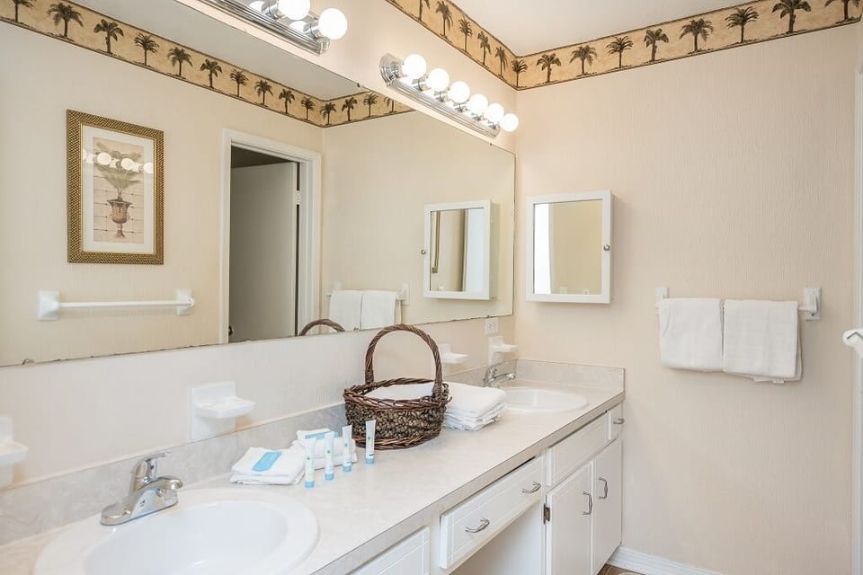 Your spacious bathroom features dual sinks with gleaming countertops, bright vanity lighting, and thoughtful touches like fresh towels and convenient toiletries—perfect for refreshing mornings and unwinding evenings.