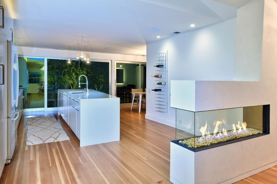 Modern open-concept kitchen and living area with cozy fireplace
