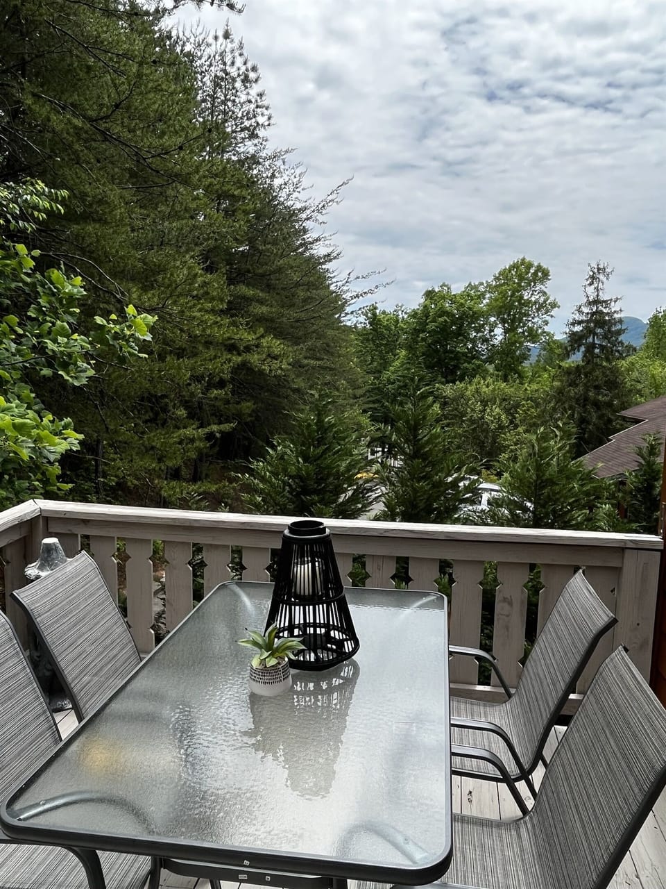 Deck off of main floor kitchen with patio table and grill