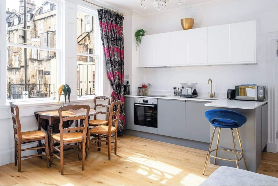 Kitchen area also has a dining table for four, plus a small breakfast bar and stool.
