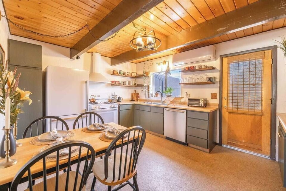 Dining table and kitchen with outdoor seating right outside the door. The fridge is new and this well stocked kitchen should have all you need. Not to mention room door dash and Uber eats delivers to this address from dozens of restaurants. 