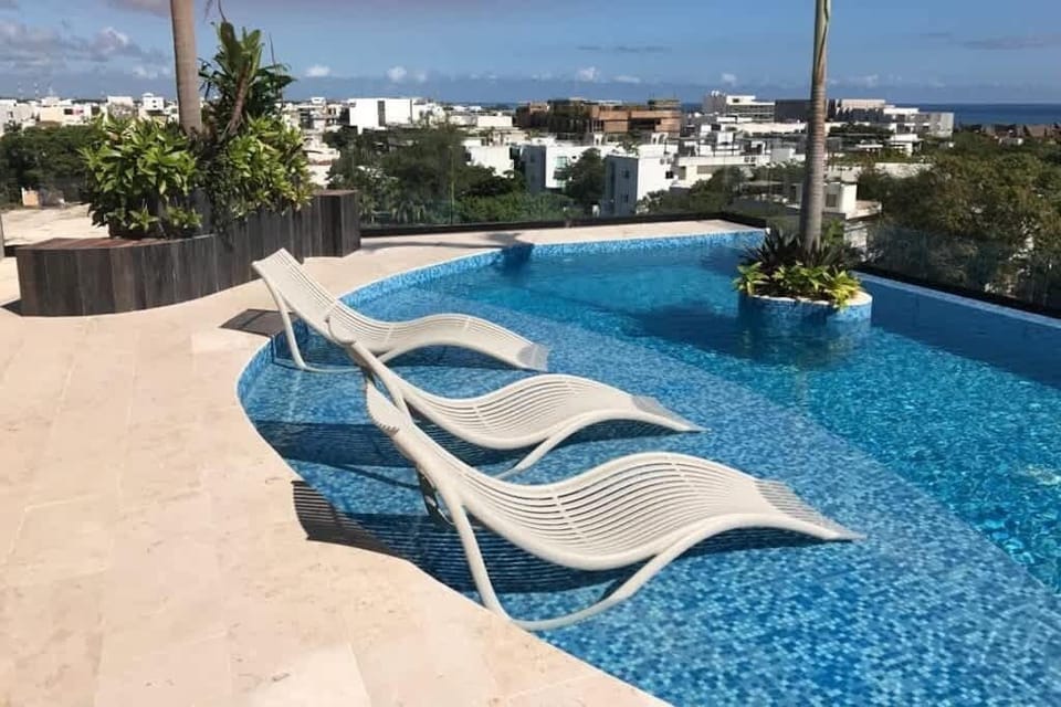 Shared rooftop pool with sun loungers