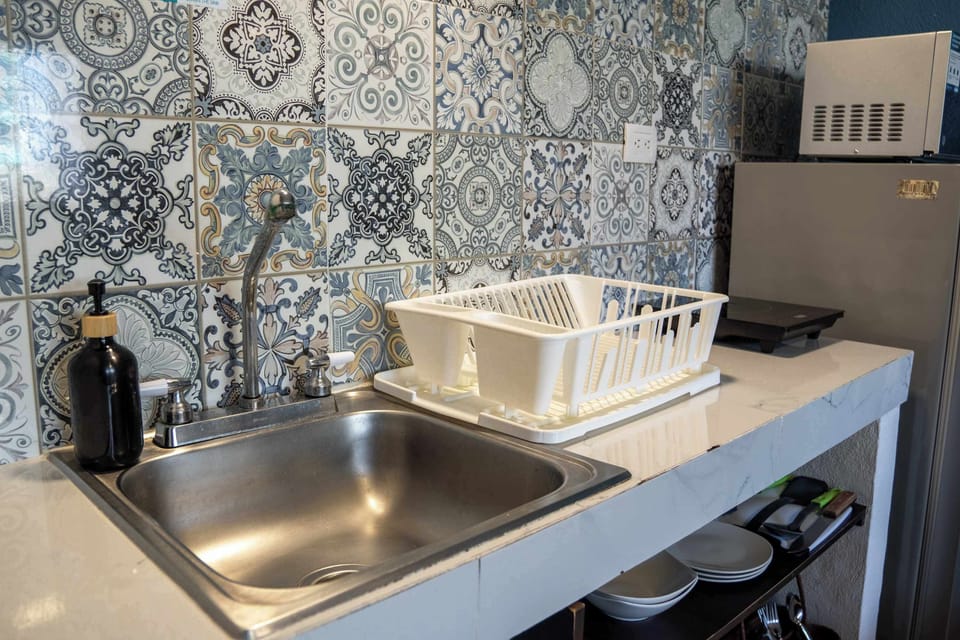 Well-equipped kitchen corner with a clean sink and classic tile backsplash, ready for everyday cooking