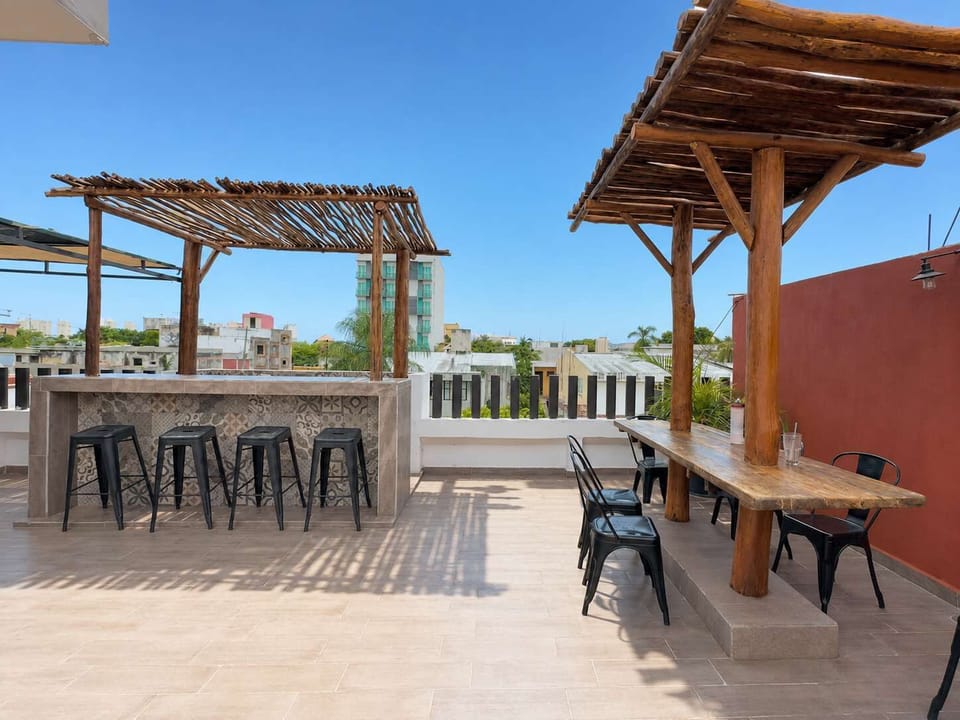 Rooftop bar under a rustic pergola, great for sunset drinks steps from Mercado 28
