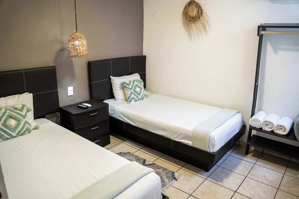 Cozy single bedroom lit by a warm pendant lamp, a peaceful retreat in the heart of Cancun