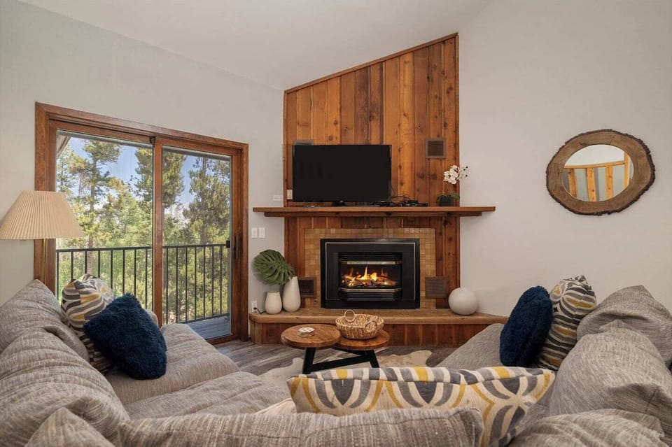 Over sized  couch with fireplace and balcony access