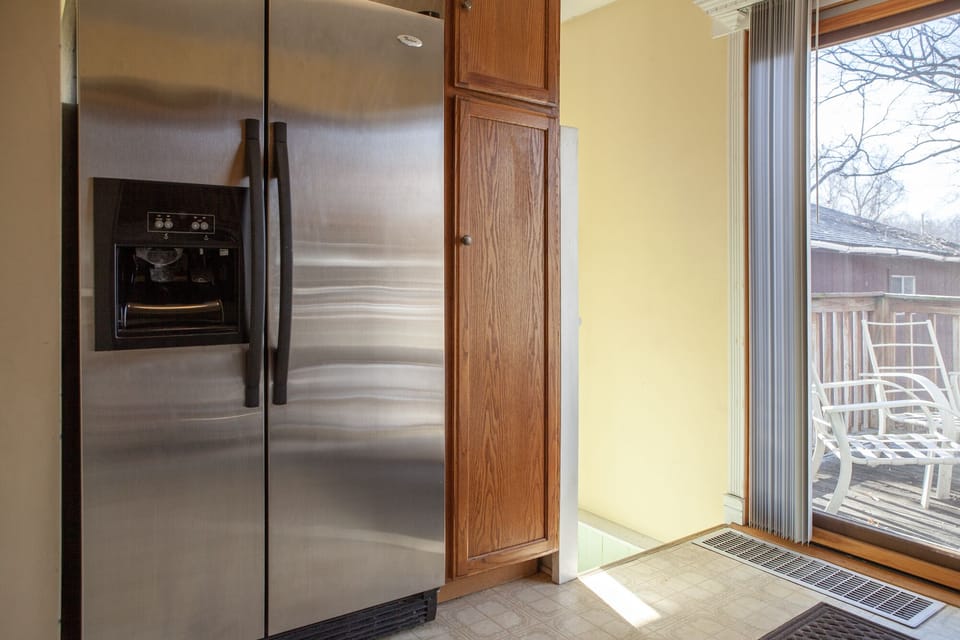Fridge and pantry, with stairs leading down to back door main entry. 