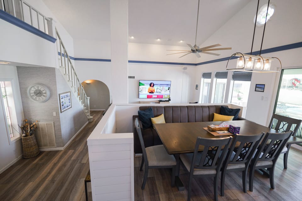 Dining table & chairs. Has a leaf inside for 10-person seating. Large fan above.