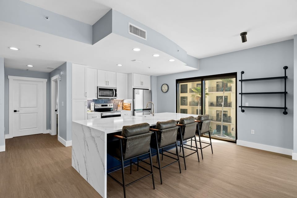 Your modern kitchen awaits with sleek marble countertops, stainless steel appliances, and stylish bar seating perfect for morning coffee.