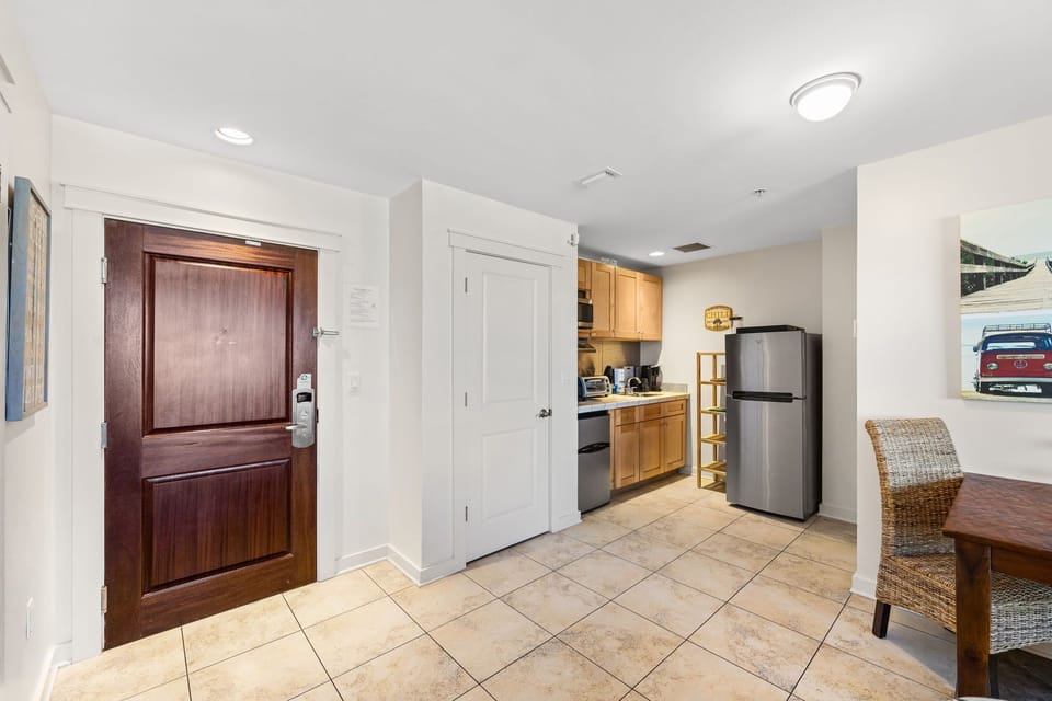 Step into your welcoming space where warm tile floors lead to a fully equipped kitchenette, complete with modern appliances and a cozy dining nook perfect for morning coffee.