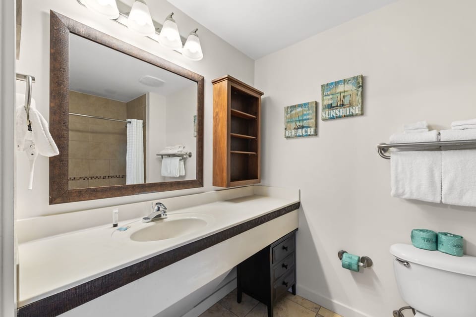 Refresh yourself in this bright bathroom with a spacious vanity, walk-in shower, and coastal touches that set a calming, beachy tone for your stay.