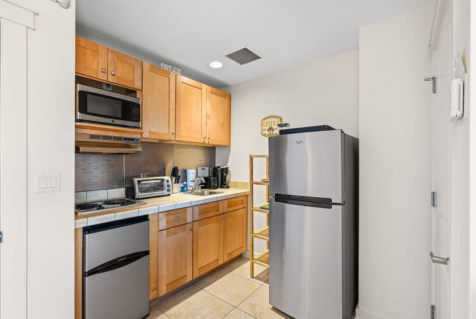 Your well-equipped kitchen offers warm wood cabinetry, stainless appliances, and counter space for meal prep, with a compact layout designed for convenient vacation cooking.