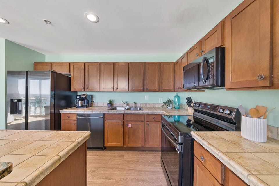 Your fully equipped kitchen features warm wood cabinetry, granite counters, and stainless appliances for preparing memorable meals together.