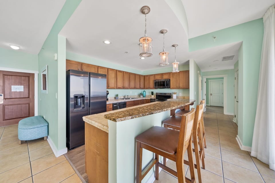 Your fully equipped kitchen features granite countertops, stainless steel appliances, and a breakfast bar perfect for morning coffee or casual meals.