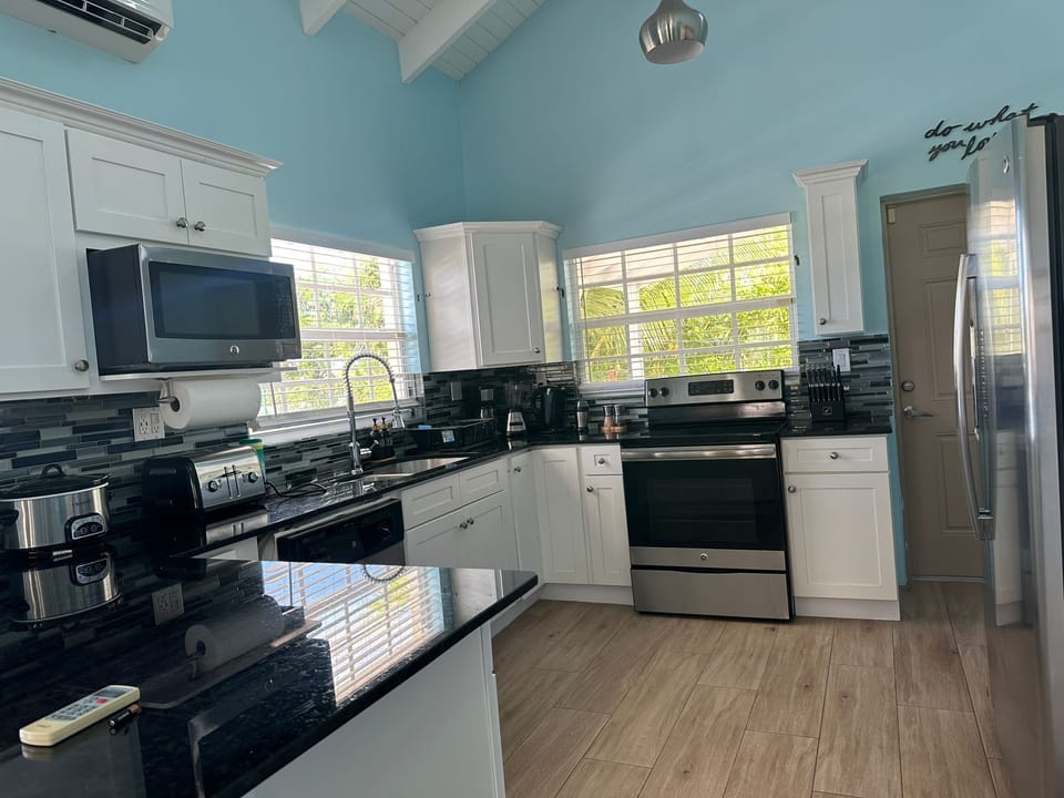 Modern kitchen with stainless appliances, utensils spices and cookware available