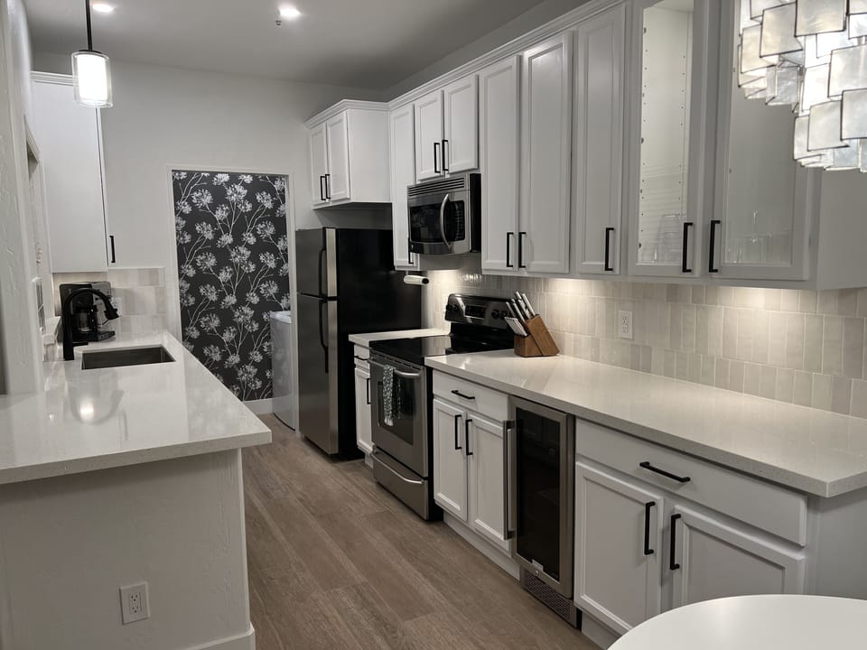 Fully stocked kitchen with undercounter beverage center and quartz countertops.