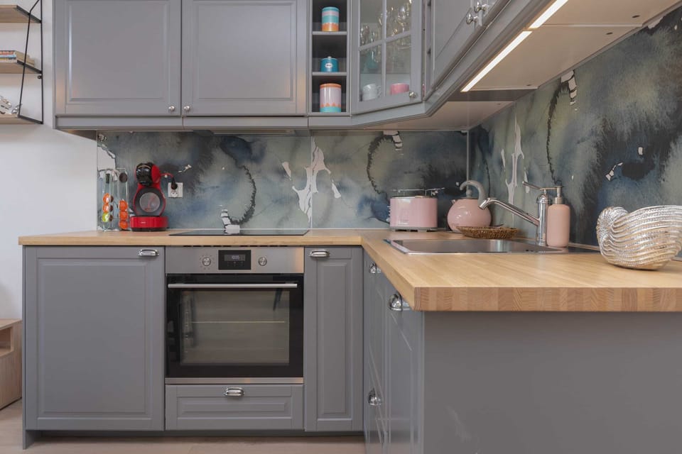 The kitchenette is well-equipped with modern appliances, including a built-in oven, stovetop, and a microwave, providing a fully functional space for cooking and dining.