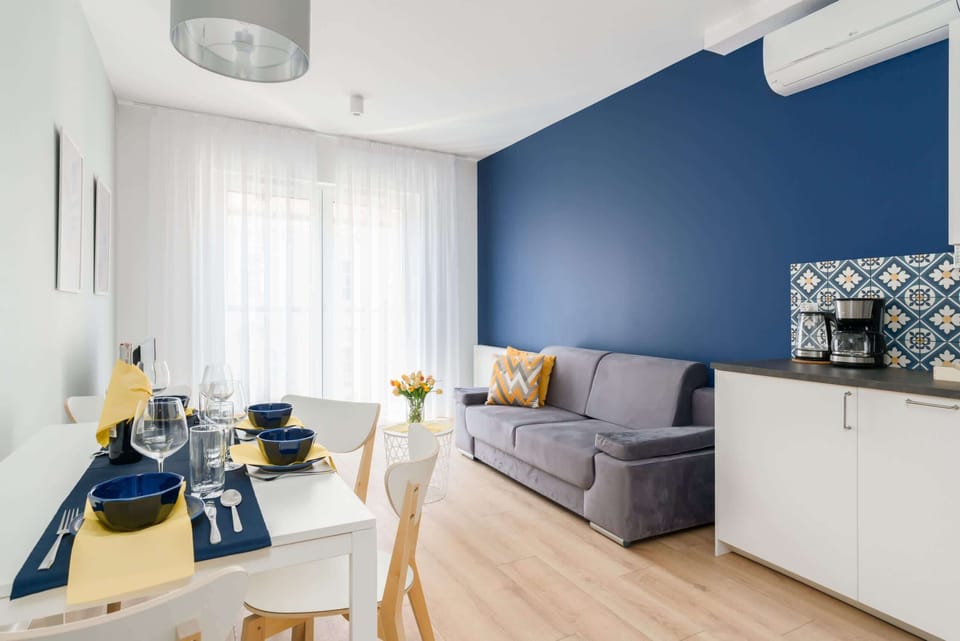 Modern and stylish living room with a sofa bed, TV and dining area.