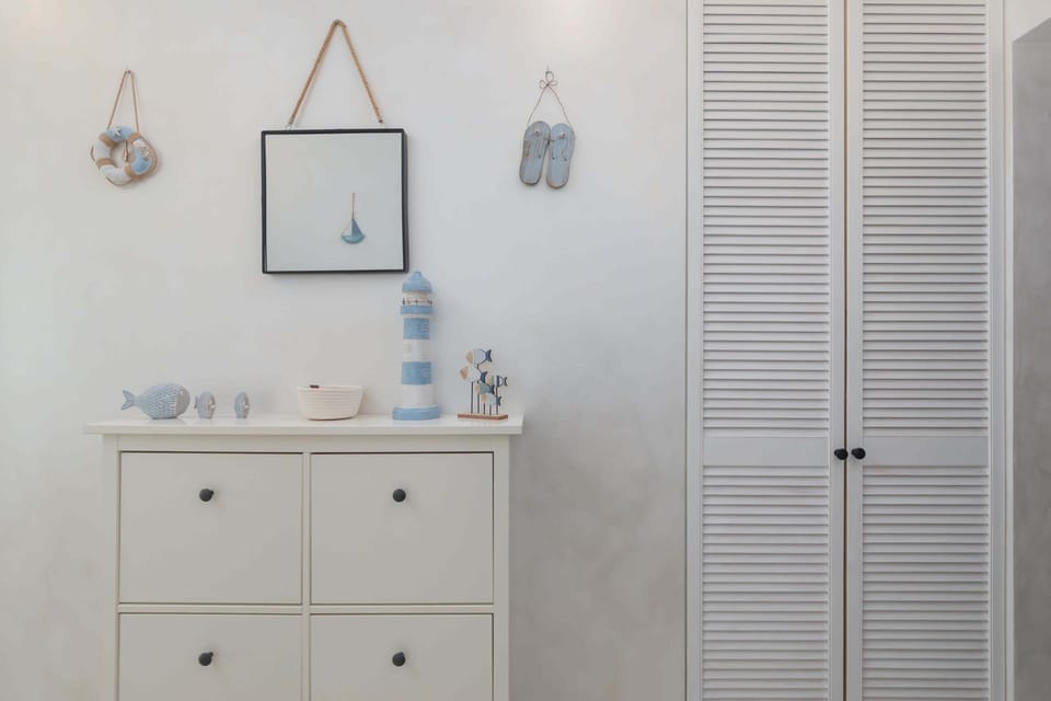 Bright apartment space with a wardrobe and chest of drawers.