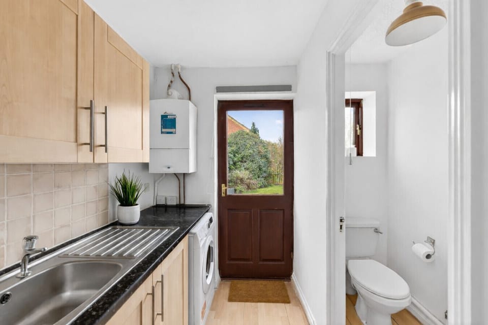 Utility room with a WC, washing machine and a large fridge freezer.