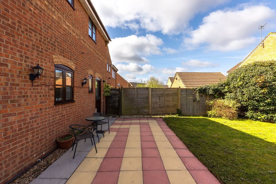 Fully fenced garden with outdoor seating.