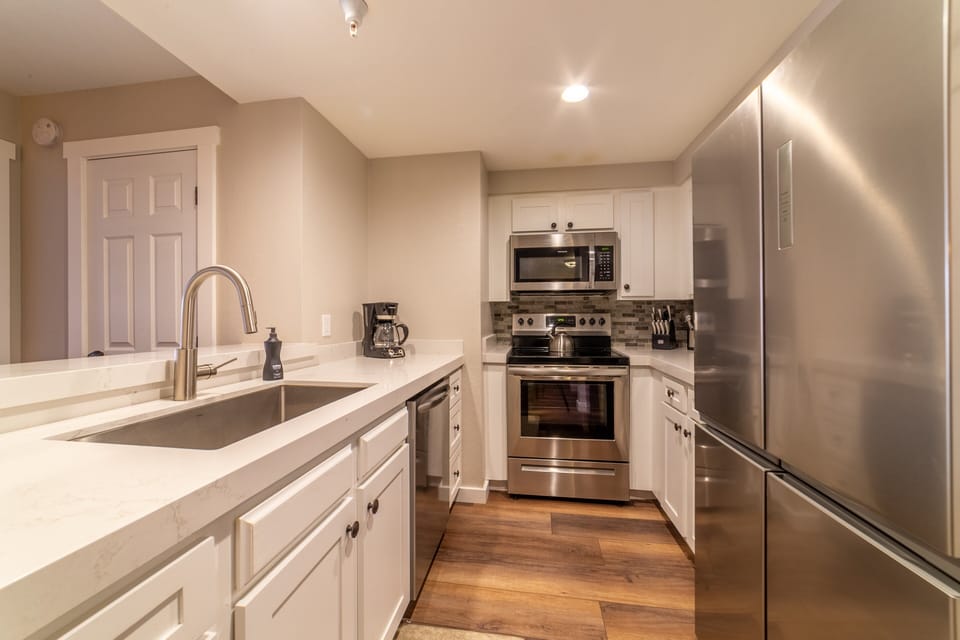 Remodeled kitchen w/ large under mount sink, stainless steel appliances and quartz countertops.