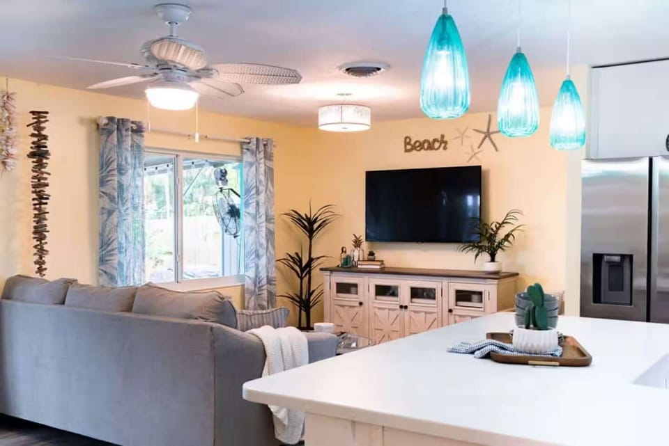 Open living area with a large television and coastal-inspired decor.