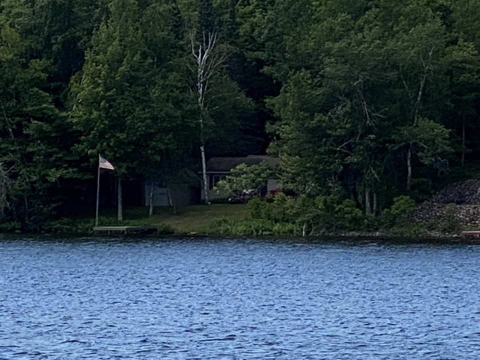 Property view from water. Flagpole on dock.