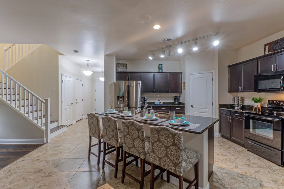 Well stocked contemporary kitchen includes counter height seating at the island.