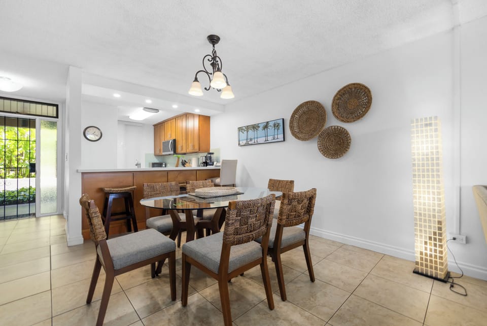 Gather around a beautiful dining table with tropical touches and warm wood accents. Your fully-equipped kitchen awaits for easy meal prep during your stay.