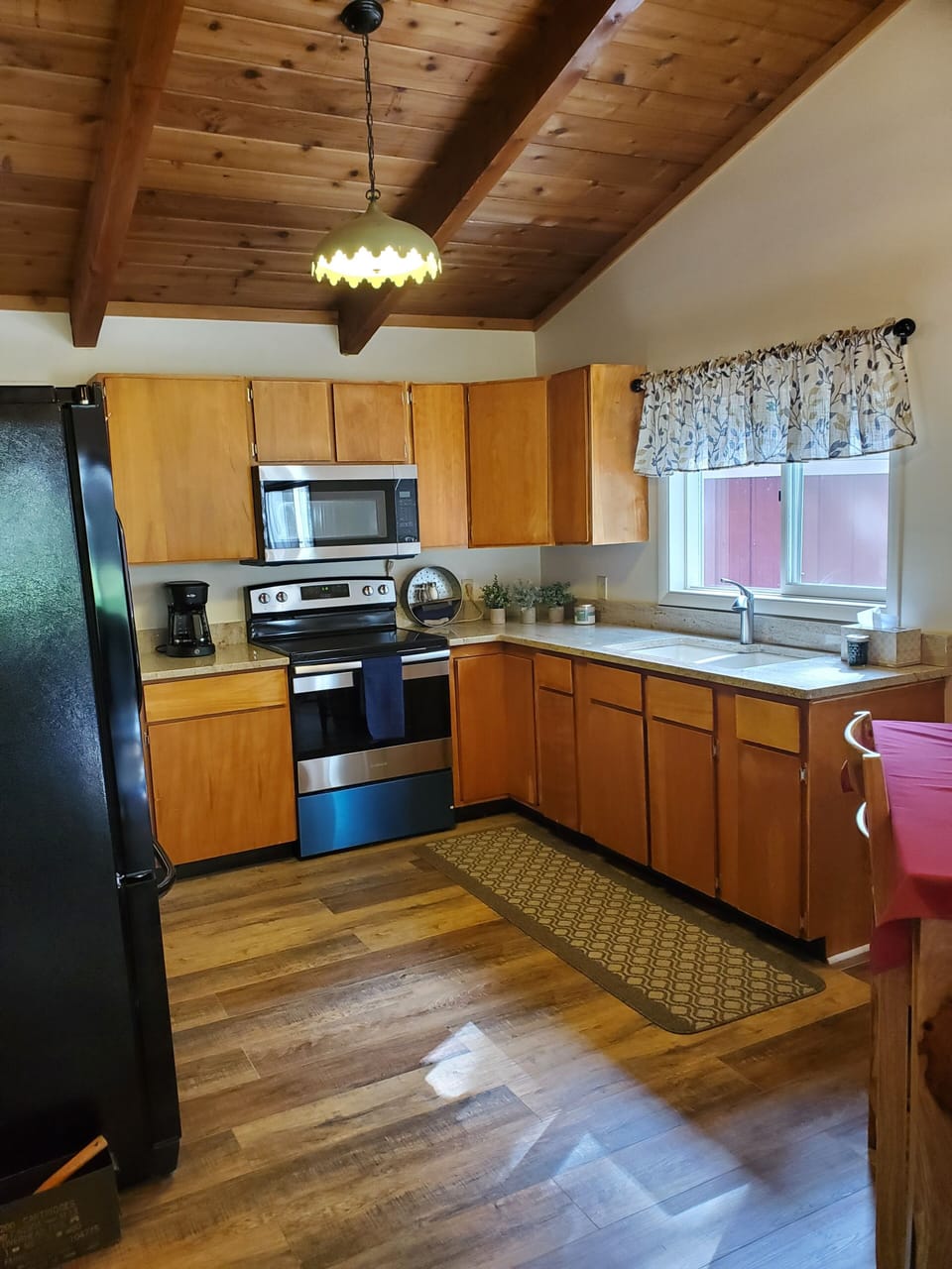 Kitchen with range oven and microwave, large refrigerator and granite top.