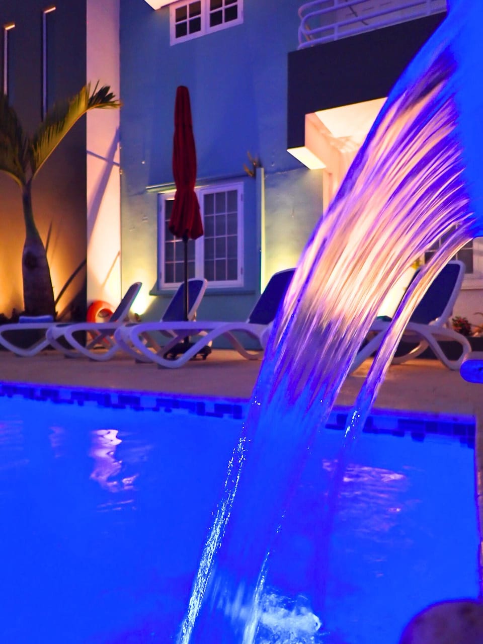 Poolside Oasis: Dive into relaxation under enchanting lights and a soothing waterfall!