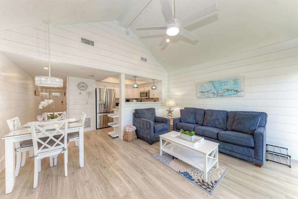 Relax in your bright, coastal-inspired living space with vaulted ceilings, comfortable seating, and an open kitchen perfect for preparing meals together.