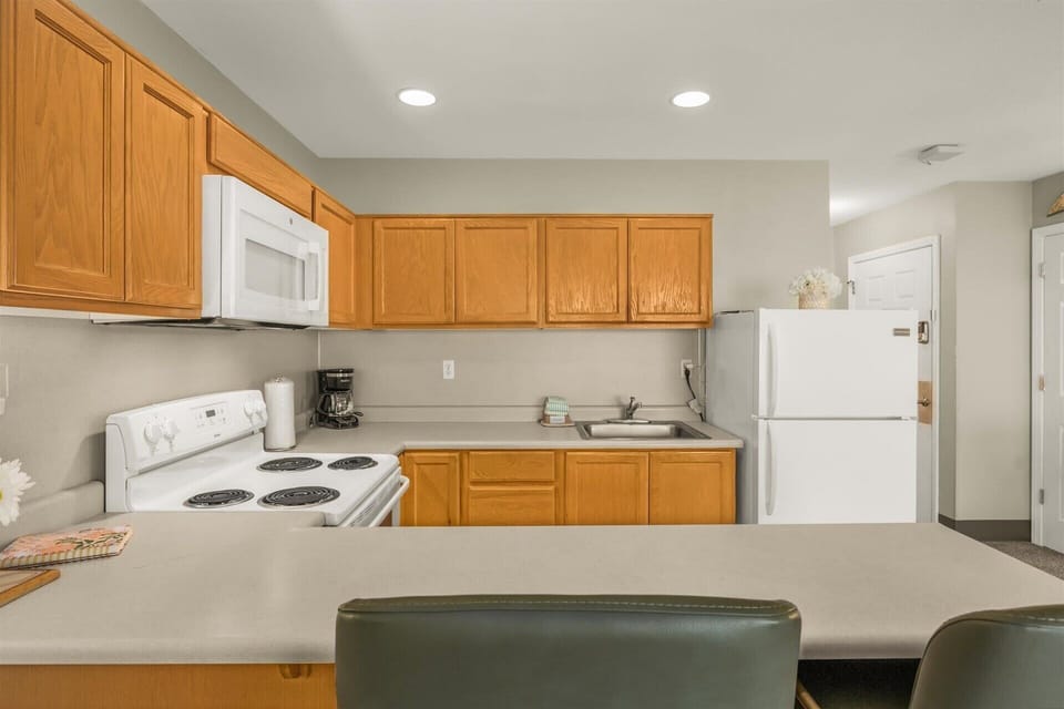 The kitchen has a stove, oven, microwave, and fridge
