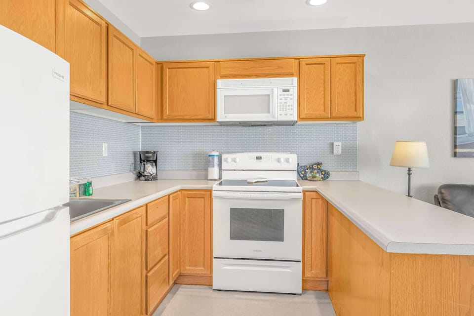 The kitchen has full-size appliances including an oven, microwave, and fridge