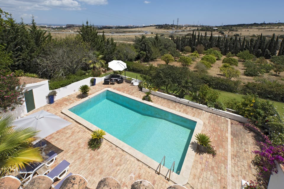From the upper floor of Villa Lorena, you have a fantastic view of the large pool terrace with its various seating areas and the wider garden. In the distance you can see Lagos and Meia Praia and the sea.