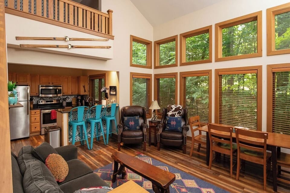 Main living area with flat screen TV, table for 6 and gas fireplace
