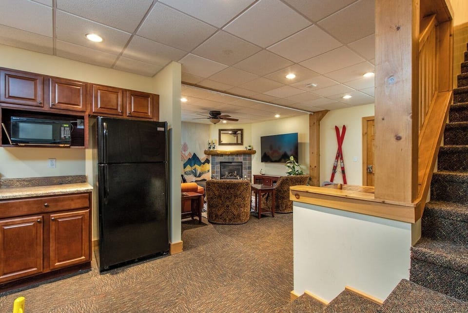 Large basement living area: kitchenette, living space, fire place, dining table