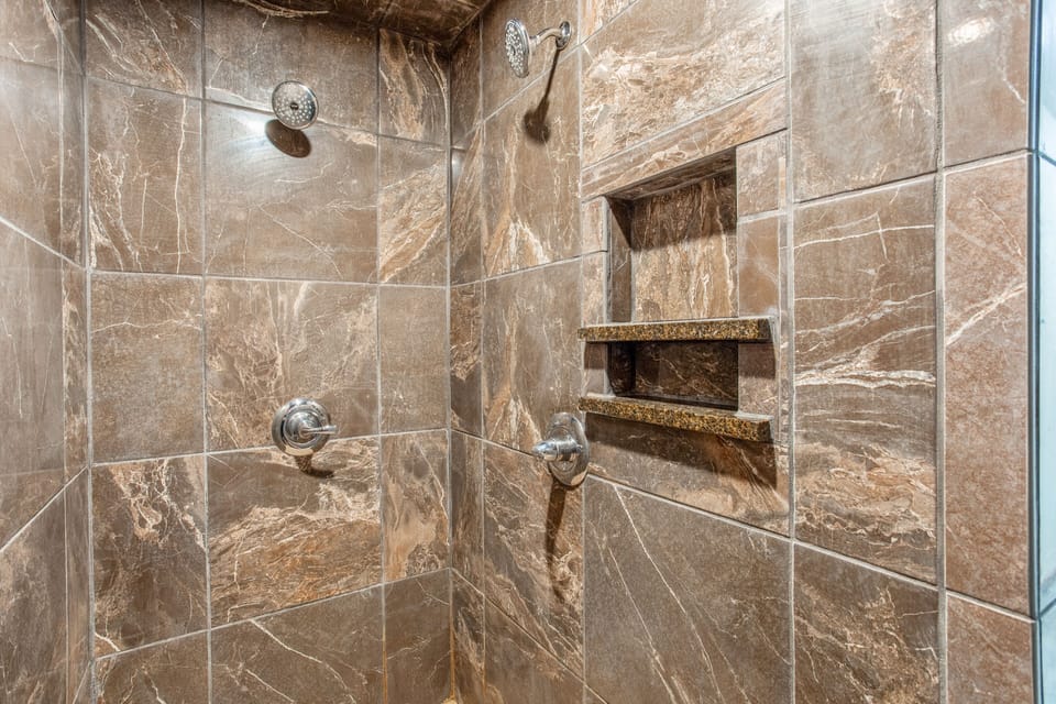 Master walk-in shower with 2 shower heads and seat.
