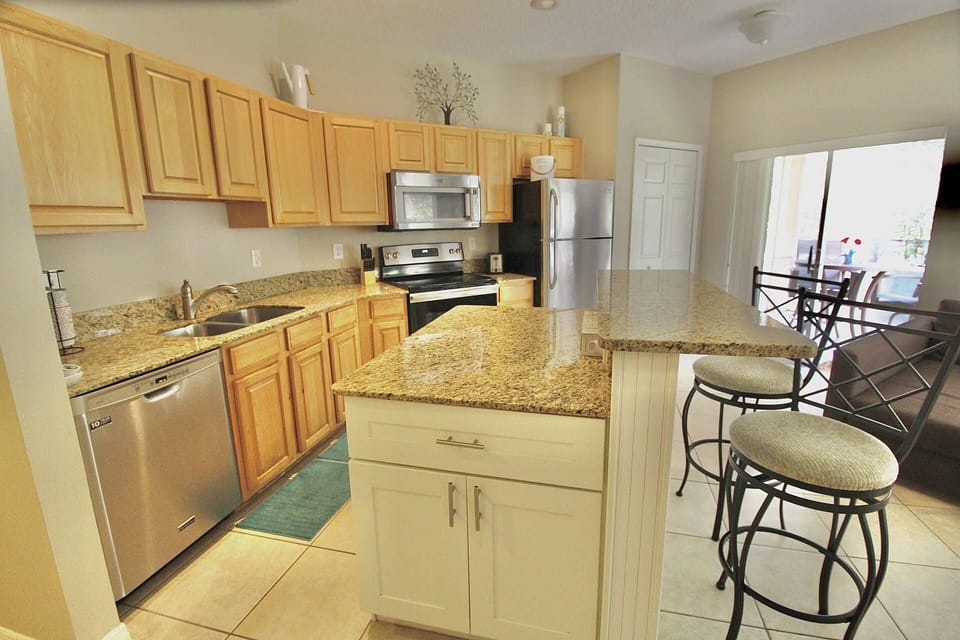 The beautiful kitchen has upgraded granite counters, an island with bar seating and stainless steel appliances.