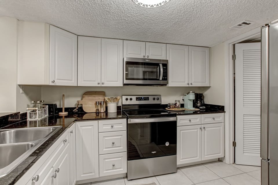 Kitchen with Granite Countertops, Stainless Steel Appliances and White Cabinetry
